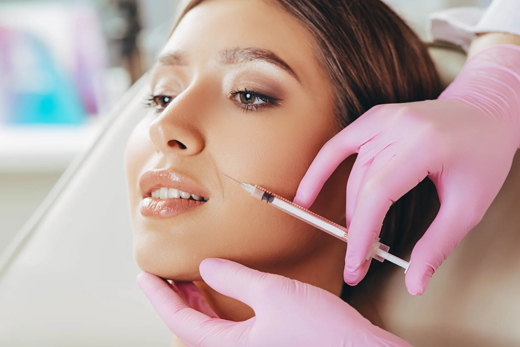 Woman receiving a dermal filler injection in the cheek.