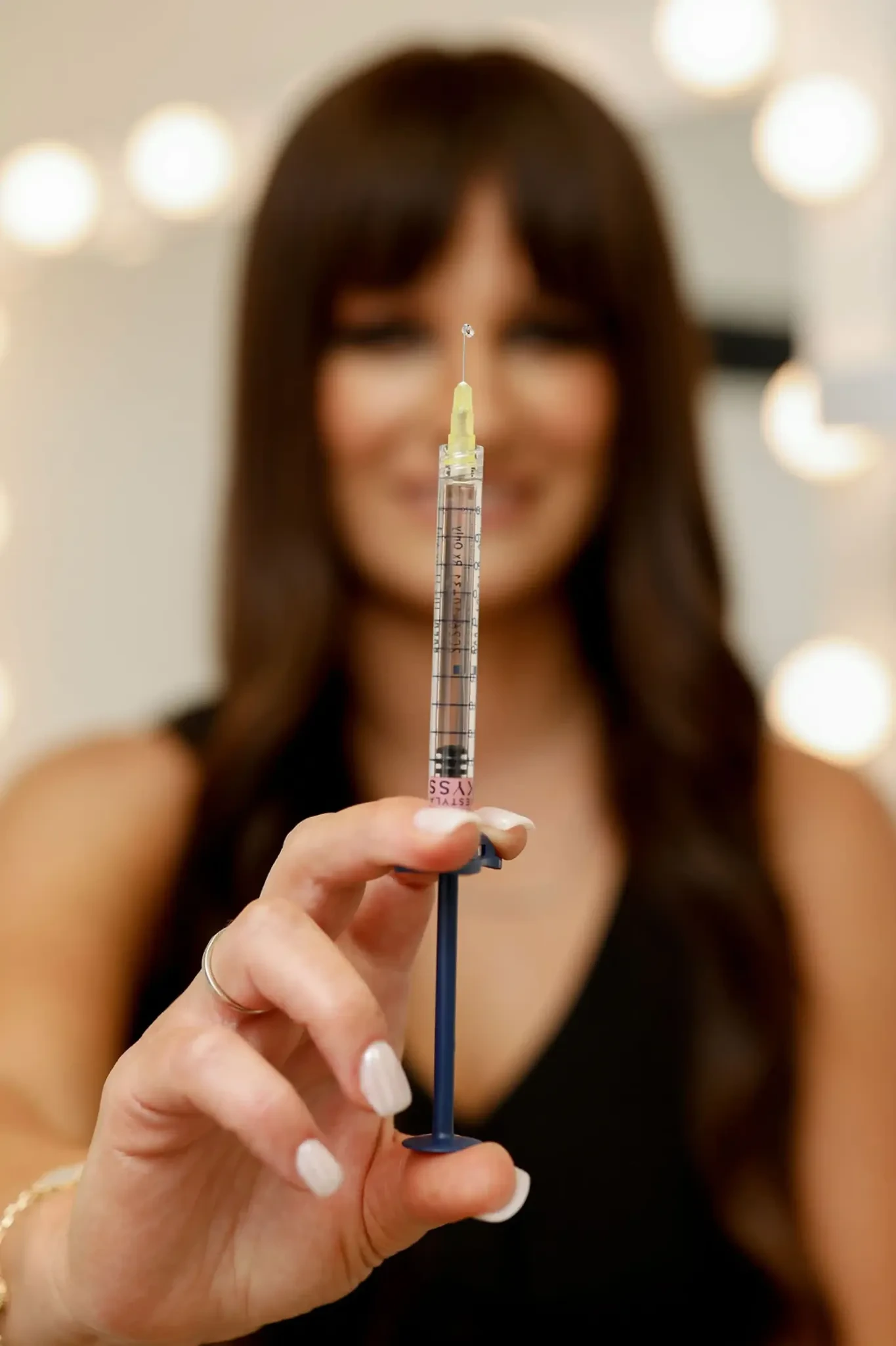 Anet holding a syringe at RejuvAnet Medical Aesthetics